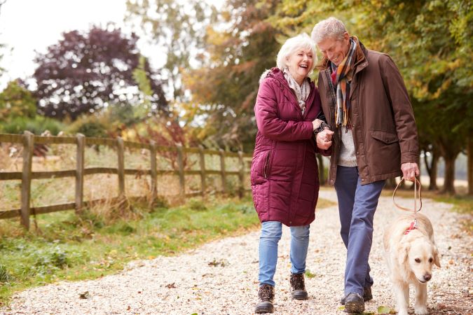 Un couple plus âgé promène son chien